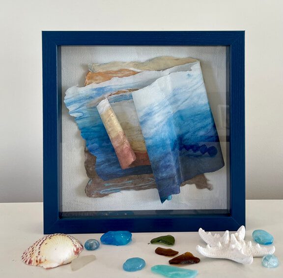 A blue frame with sea shells and a piece of paper.