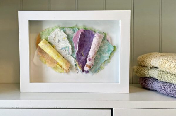 Letters to Theo, 7 x 5 x 1 inches, white shadow box frame displayed on a shelf beside colorful folded towels.